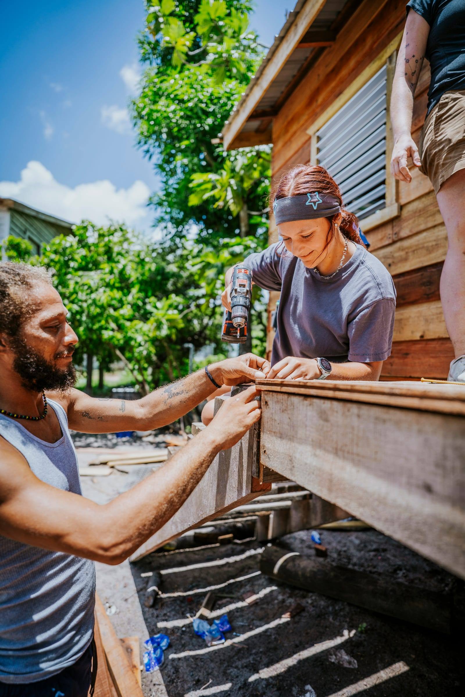 A local builder and a volunteer fit boards to a wall together